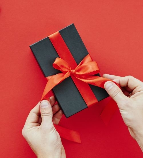 A red gift wrapped with a golden ribbon